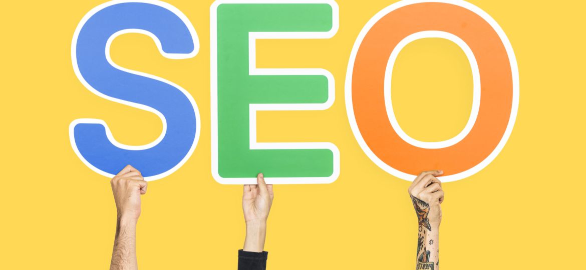 Hands holding up colorful letters forming the abbreviation SEO (Demo)